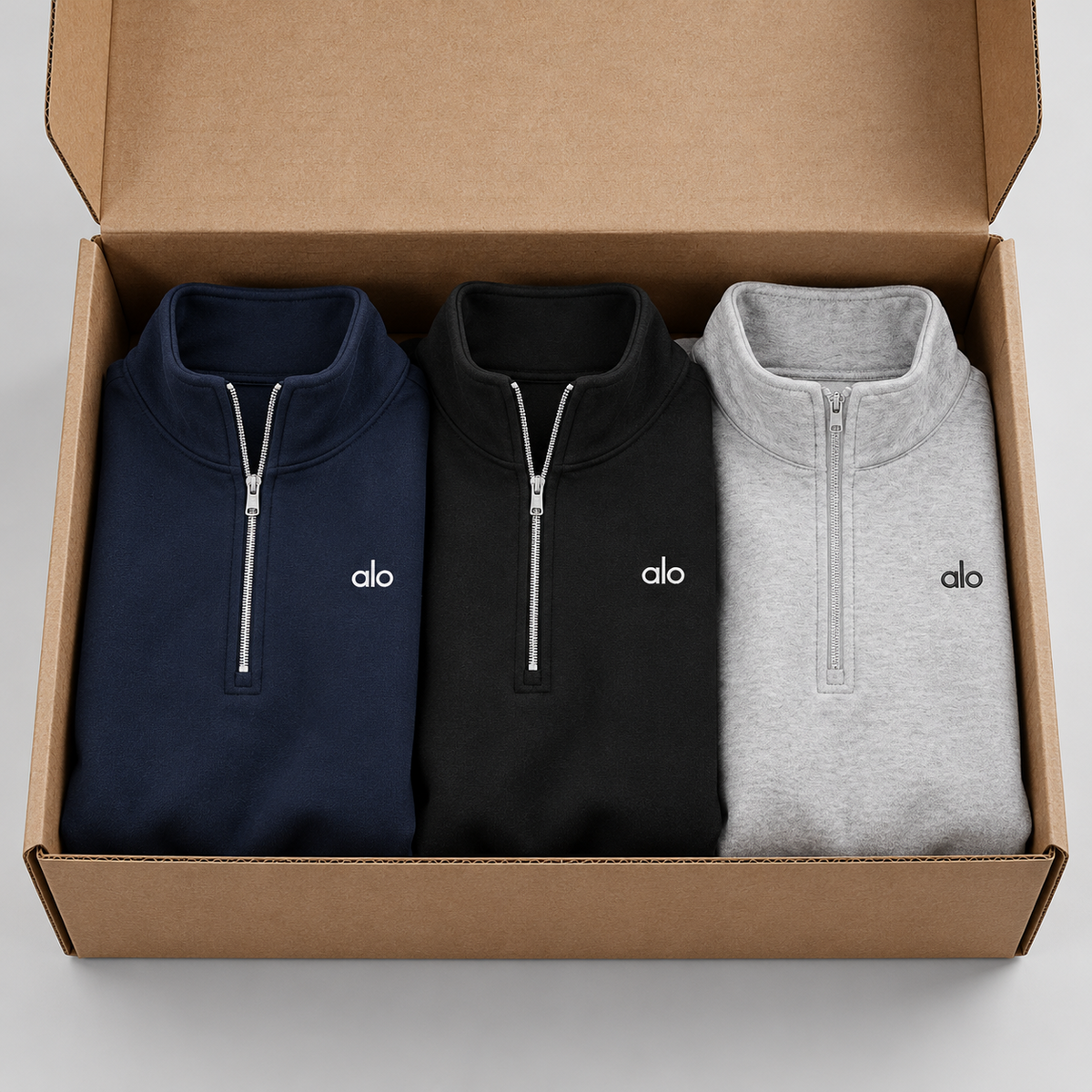 Alo Quarter Zip azul marino, negro y gris en caja kraft