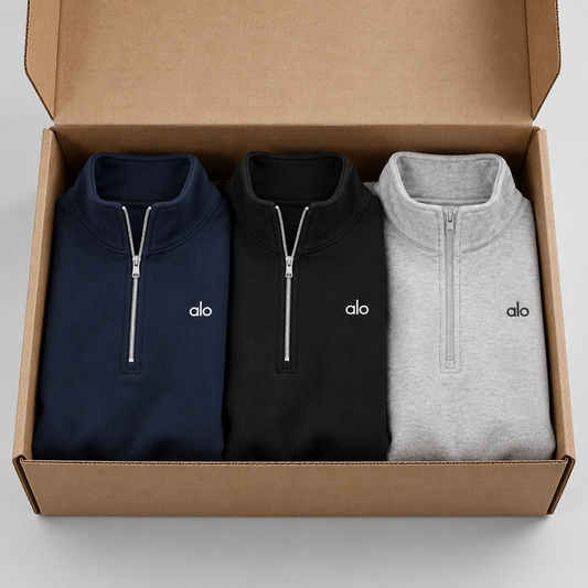 Alo Quarter Zip azul marino, negro y gris en caja kraft